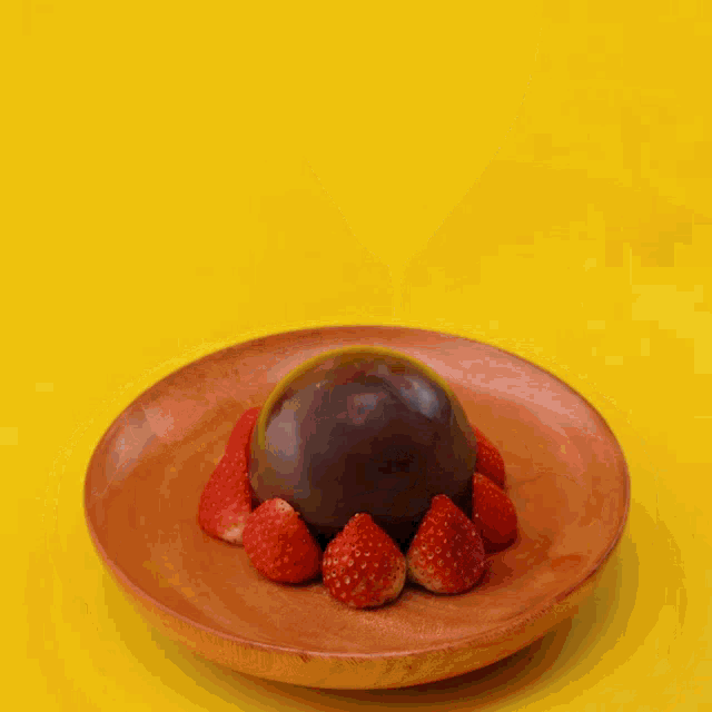 a chocolate dessert with strawberries on a brown plate