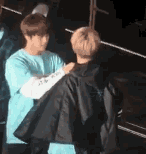 two men are hugging each other on a stage .
