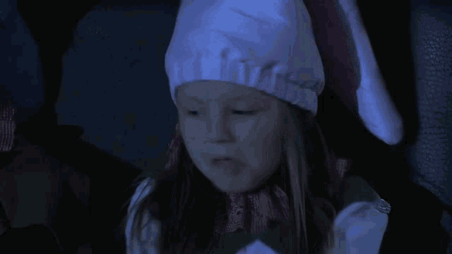 a little girl wearing a pink hat and a green and white dress
