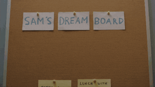 a man is standing in front of a bulletin board with sticky notes on it that says goals