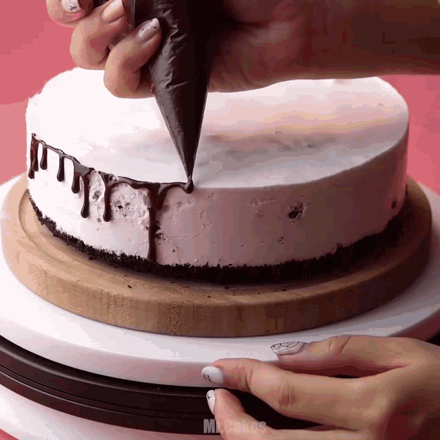 a cake is being decorated with chocolate and the words mr. cakes are visible