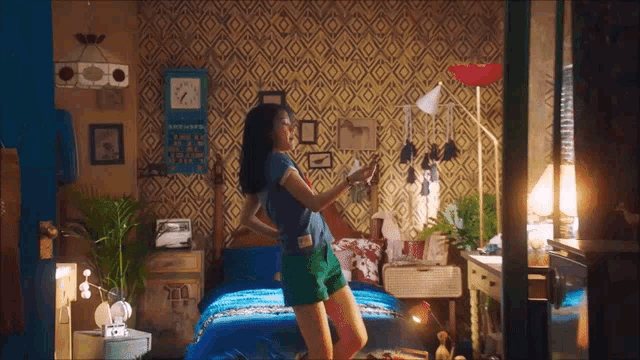 a woman is dancing in a bedroom with a clock on the wall that says 7:00