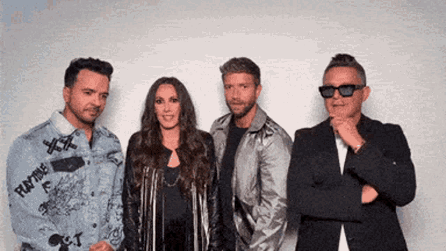 a group of people standing next to each other with one man wearing sunglasses and a jacket that says ' ain time '