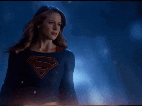 a woman in a superman costume is holding a beam of light in her eyes