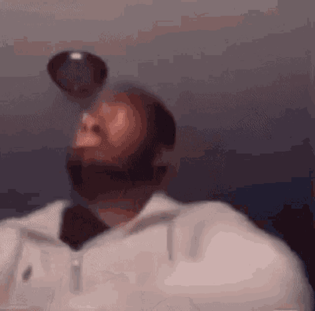 a man with a beard is drinking from a bottle while wearing headphones .