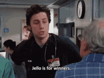 a man with a stethoscope around his neck is talking to a man in a hospital room .