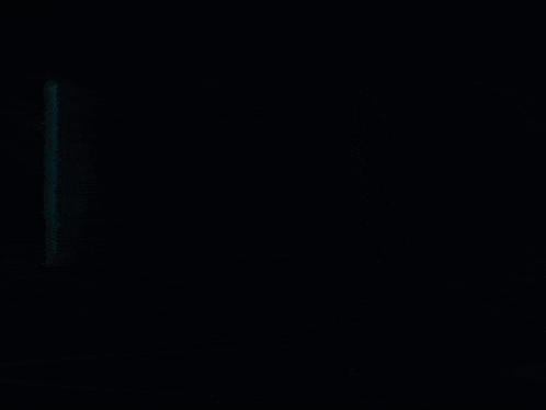 a man in a white jacket stands in the dark