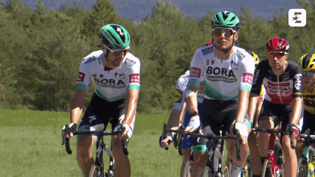 a group of men riding bicycles with bora on their uniforms