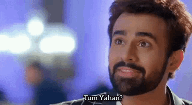 a man with a beard is making a funny face while talking to another man .