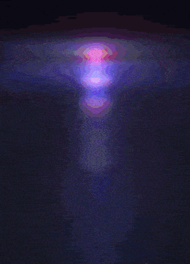a purple and pink glowing object is floating in the dark