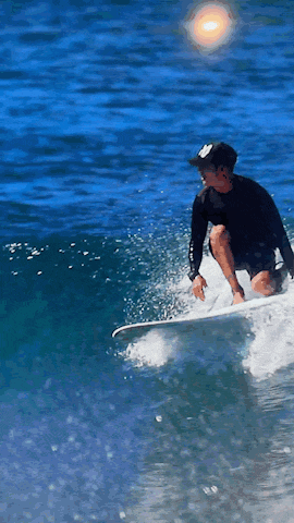 a man riding a wave on a surfboard wearing a black shirt that says ' abercrombie & fitch ' on it