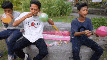 a man wearing a jordan shirt blowing up balloons