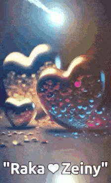 a couple of hearts sitting next to each other on a table with the words `` raka zeiny '' written on it .