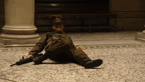 a soldier laying on the floor with a gun