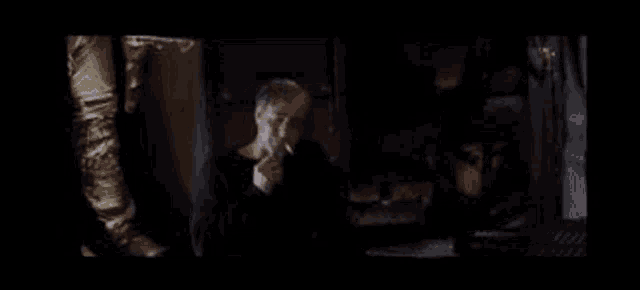 a man smoking a cigarette in a dark room