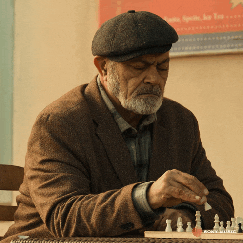 a man playing a game of chess with a sony music logo in the background