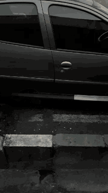 a black car is parked on the side of a street