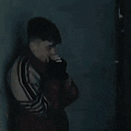 a man is standing in front of a wall in a dark room .