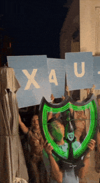 a group of people hold up signs that say xau