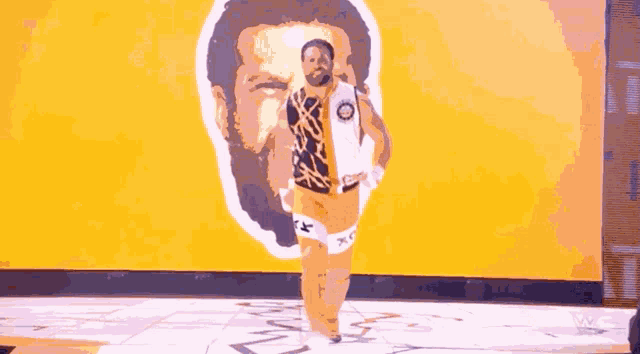 a man with a beard is walking in front of a wall with a drawing of a man 's face on it