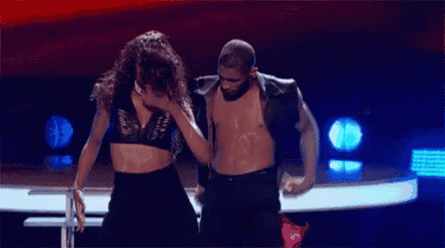 a man and woman are dancing on a stage .