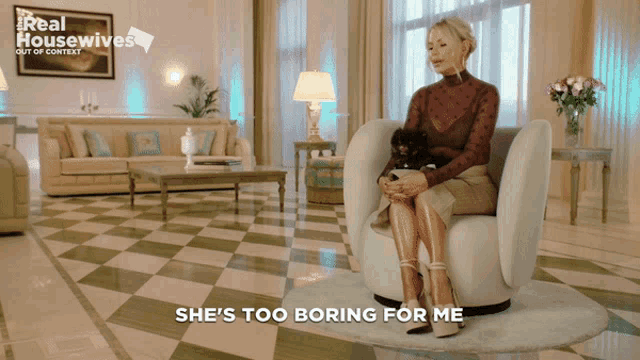 a woman is sitting in a chair with a dog and the words she 's too boring for me behind her