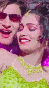 a man and a woman wearing sunglasses are smiling for the camera .