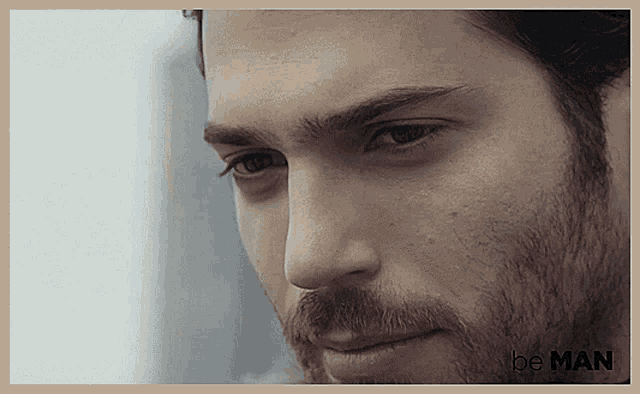 a close up of a man 's face with the words " be man " on the bottom