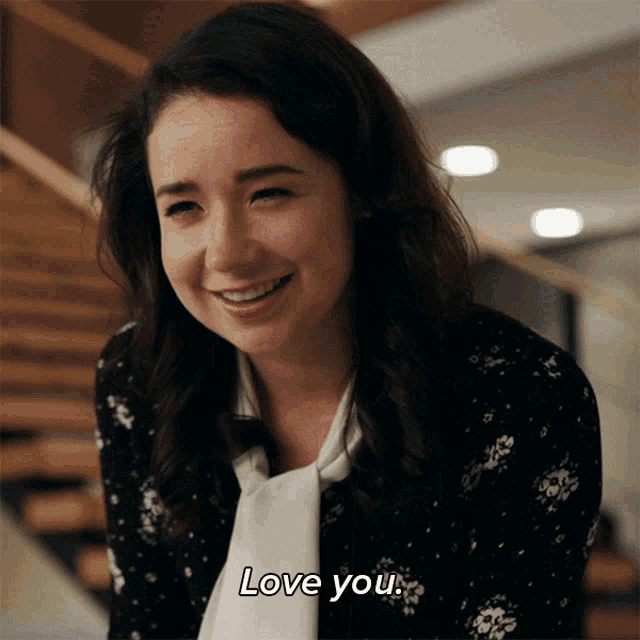 a woman is smiling and says " love you " in white letters