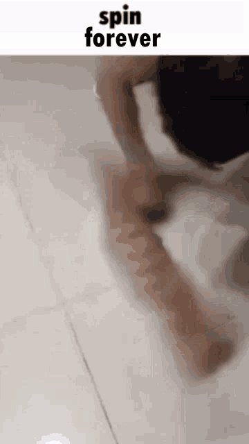 a person is playing with a cat on the floor and the cat is moving in a circle .