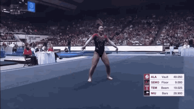 a female gymnast performs a trick in front of a crowd at a gymnastics competition sponsored by at & t
