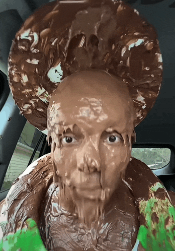 a person with their face covered in chocolate looks at the camera