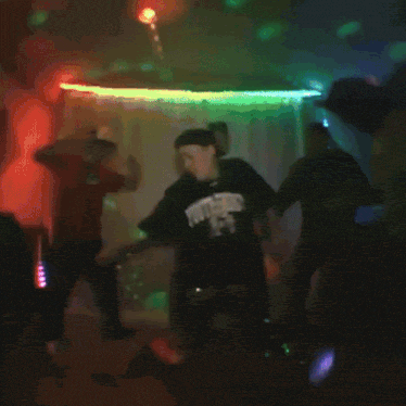 two men are dancing in front of a disco light