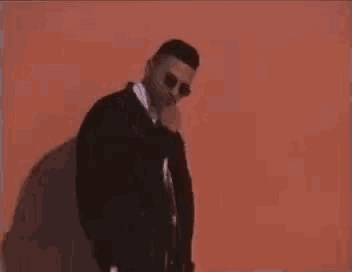 a close up of a man wearing sunglasses and a suit .