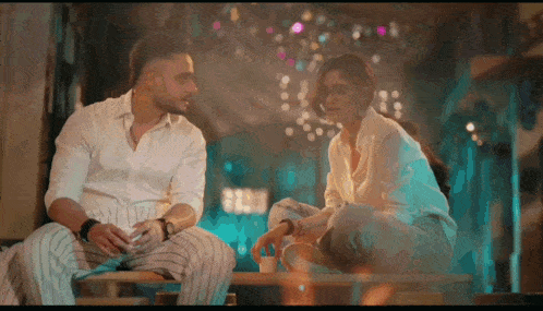 a man and a woman are sitting on a bench and talking to each other