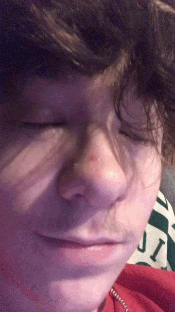 a close up of a person 's face with their eyes closed and the word jic visible