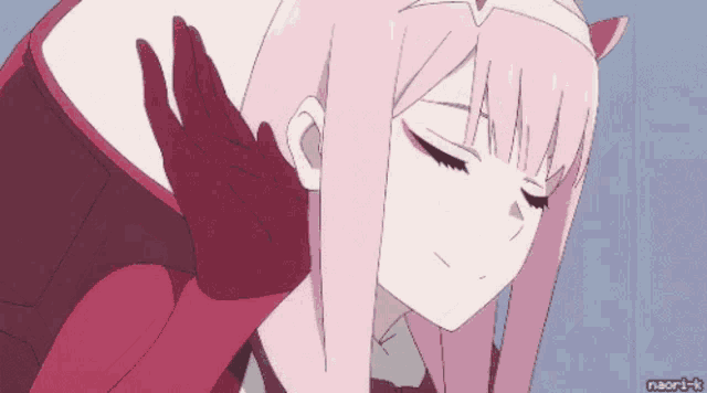 a girl with pink hair and red gloves is waving her hand .