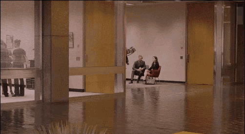 a group of people are walking through a hallway with a yellow curb in the foreground