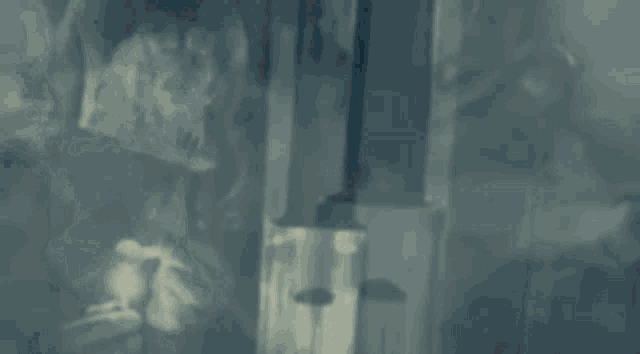 a close up of a sword surrounded by smoke in a dark room .
