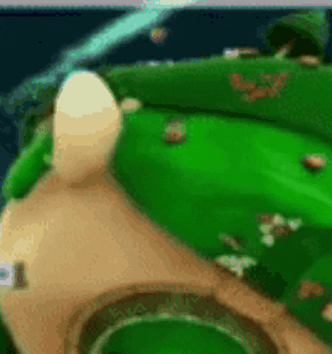 a blurred image of a green field with a white object in the foreground