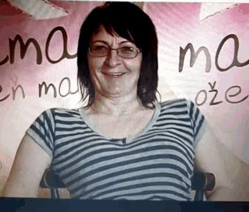 a woman wearing glasses stands in front of a sign that says mama