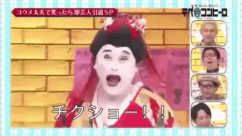 a group of people are standing in front of a brick wall and one of them is wearing a geisha costume .