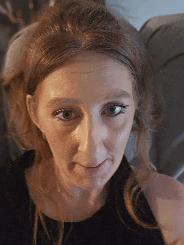 a close up of a woman 's face with a black top