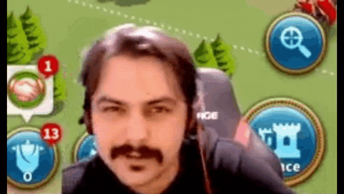 a man with a mustache is sitting in front of a screen with a map in the background .