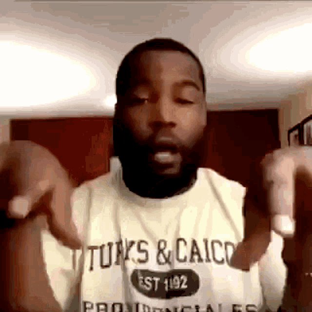 a man with a beard is wearing a t-shirt that says turks & caico