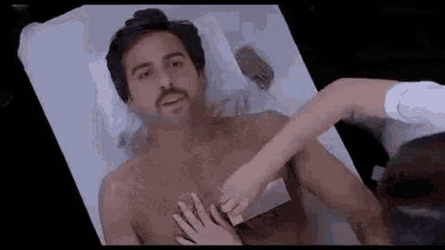 a woman is waxing a man 's chest in a salon .