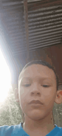 a young boy in a blue shirt is taking a selfie