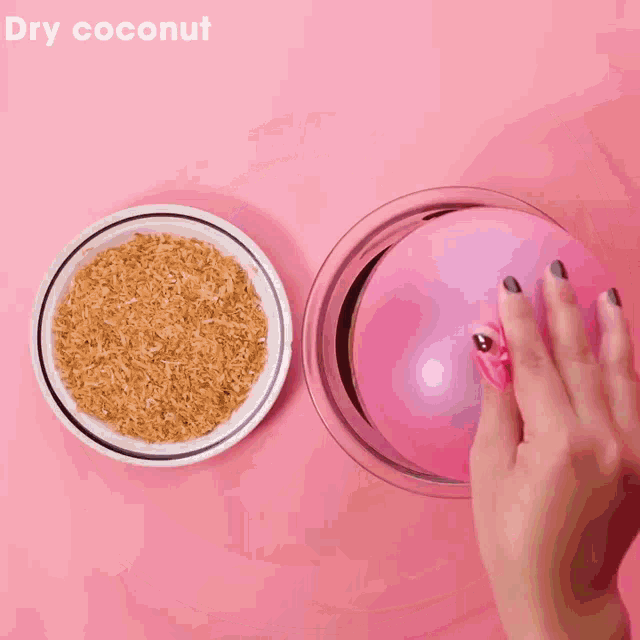 a pink balloon is being filled with dry coconut next to a bowl of rice