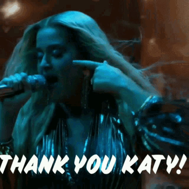 a woman singing into a microphone with the words thank you katy written on the bottom