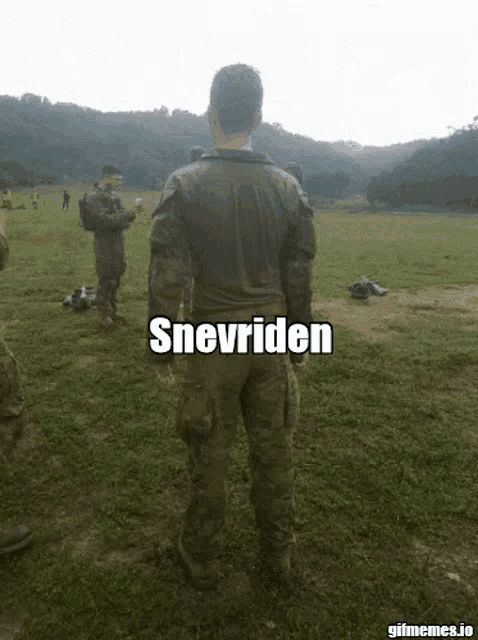 a man in a military uniform is standing in a grassy field with the word snevriden on his back